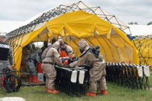 Courtesy Photo Guardsmen with the Texas National Guard's 836th Chemical Company, 6th Chemical, Biological, Radiological, Nuclear, and High-Yield Explosives (CBRNE) Enhanced Response Force Package, Joint Task Force 136 (Maneuver Enhancement Brigade), move an injured civilian into a chemical decontamination line during a training exercise at Govalle Waste Water Treatment Plant in Austin, Texas, as part of their weeklong annual training period April 22, 2015. (U.S. Army National Guard photo by Spc. Martha Guerrero/Released)